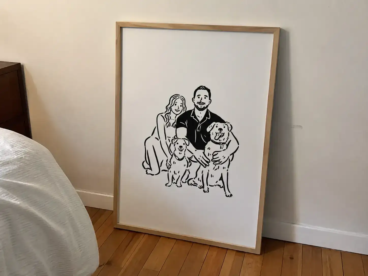 Black line-art family poster with two dogs displayed in a light frame
